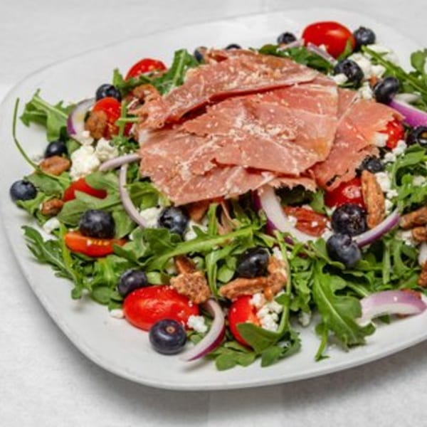 Arugula salad with prosciutto, blueberries, cherry tomatoes, red onion, and feta cheese.